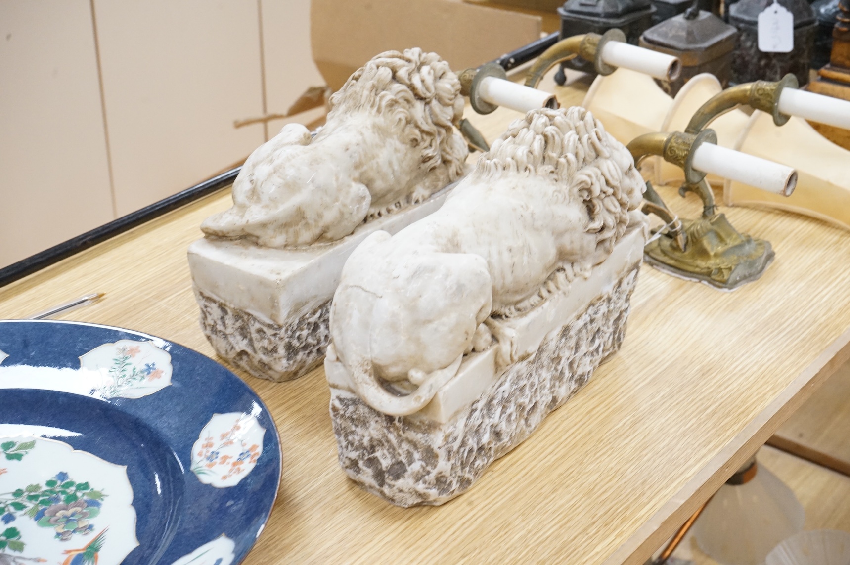 A pair of marble resin Canova lions, 30cm wide